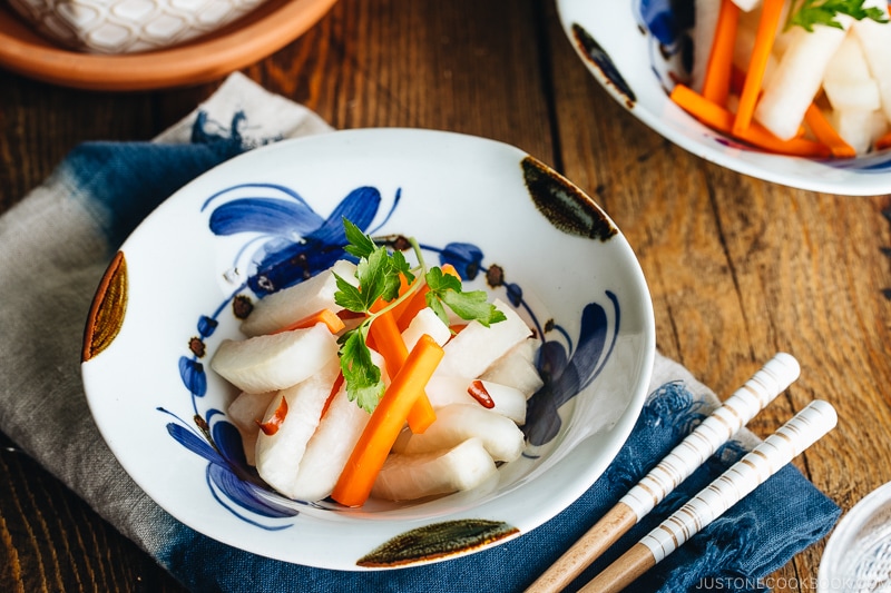 Daikon and carrot pickled in sweet vinegar, served in Japanese ceramic bowls.