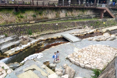 boy and girl on rock path in canal