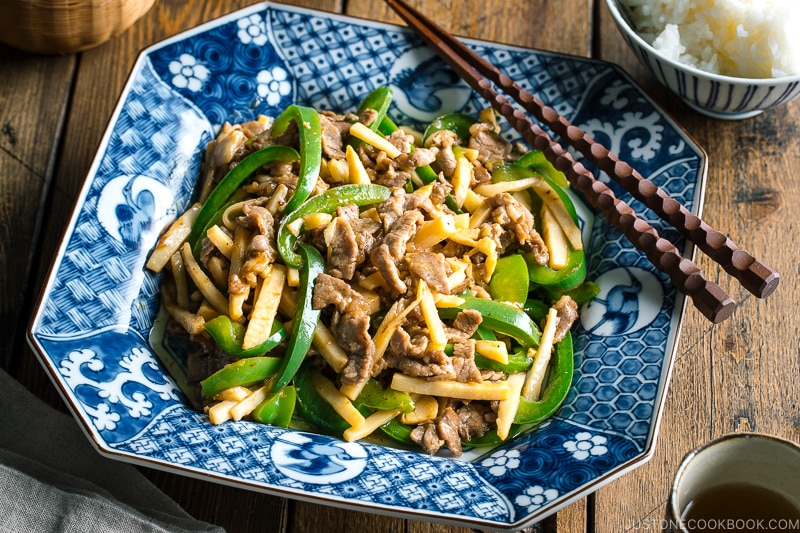 A Japanese blue and white ceramic containing Beef and Green Pepper Stir Fry.