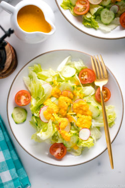 Carrot ginger dressing drizzled on the refreshing iceberg lettuce and cucumber slices.