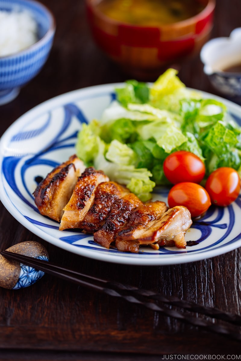 Chicken teriyaki served with salad on a plate.