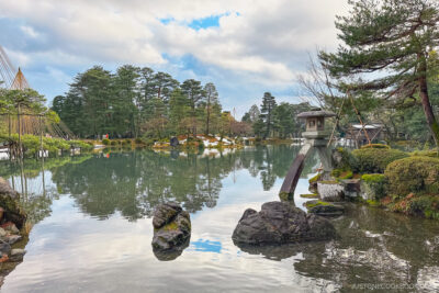 a stone lantern in a large pond at Kenroku-e