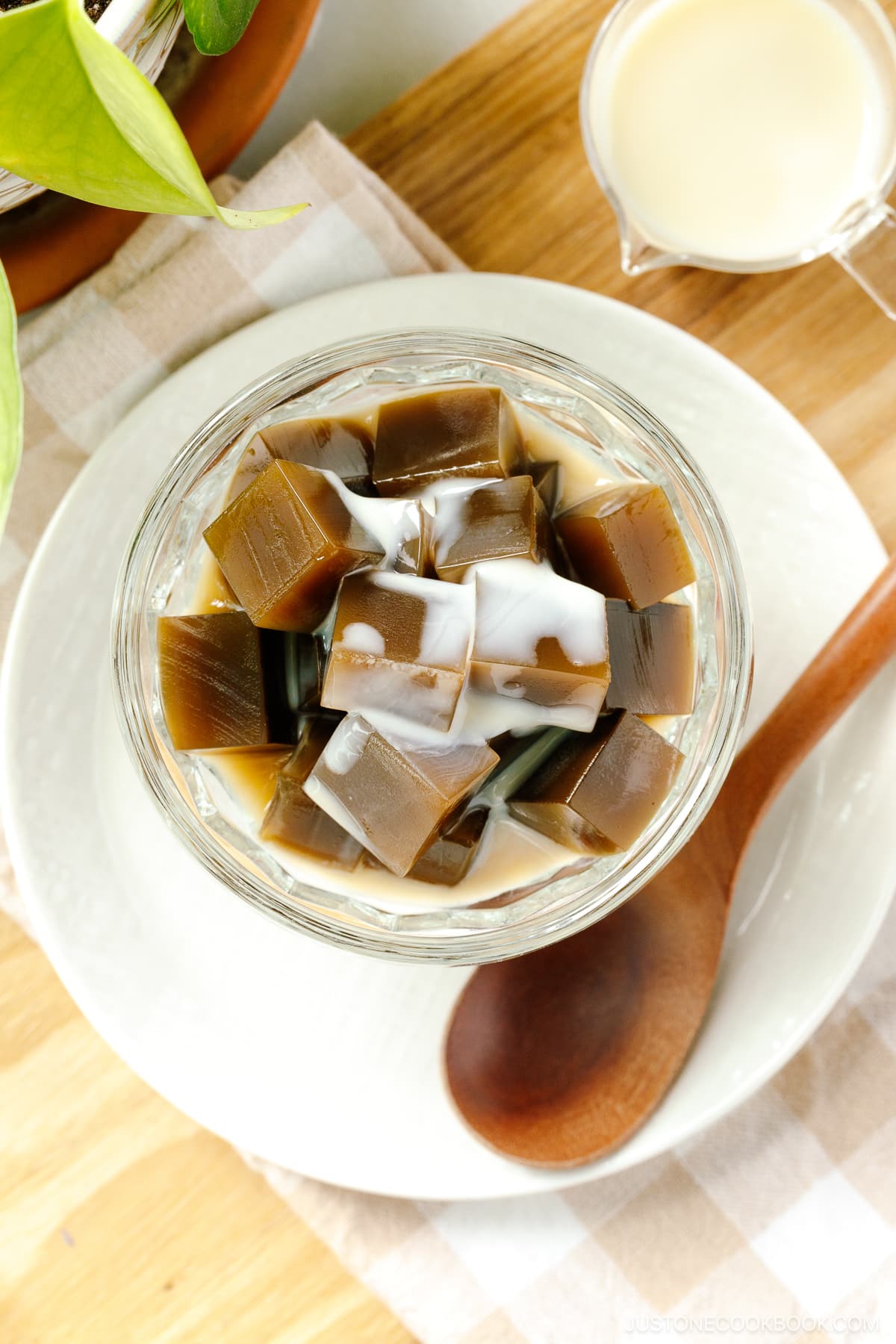 A glass bowl containing cubed Hojicha Jelly drizzled with sweetened condensed milk.