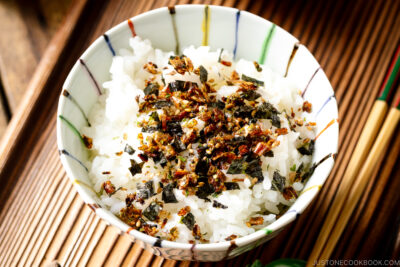 A rice bowl containing steamed rice sprinkled with furikake rice seasoning.