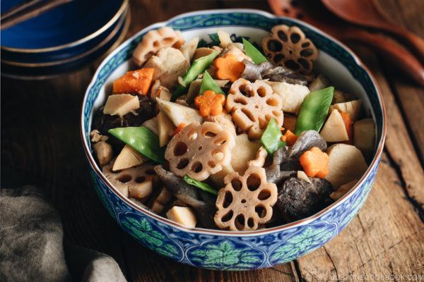 A blue Japanese bowl containing Nishime, simmered vegetables and chicken.