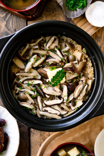 A Hario donabe (Japanese clay pot) containing Japanese Mushroom Rice topped with butter, chives, and sea salt flakes.