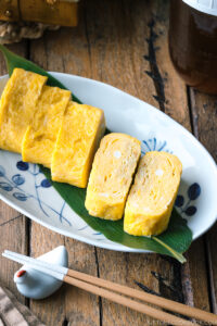 An oval plate containing Japanese sweet rolled omelet.