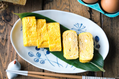 An oval plate containing Japanese sweet rolled omelet.