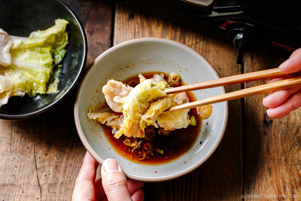 Dipping pork belly slice and napa cabbage in ponzu sauce.