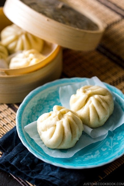 A blue dish containing Steamed Pork Buns (Nikuman).