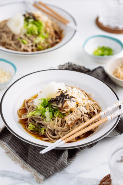 A ceramic bowl containing Oroshi Soba, chilled buckwheat noodles with grated daikon and savory sauce.