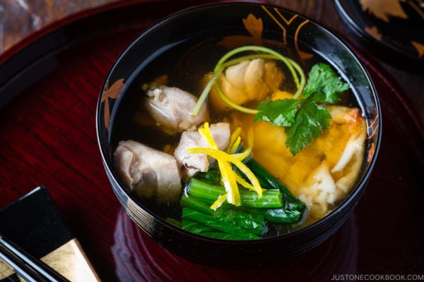 A black and gold lacquered bowl containing Japanese New Year Soup Ozoni.