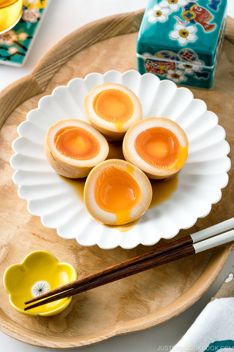 A white ceramic plate containing ramen eggs.