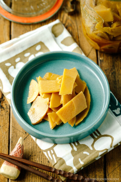 A blue plate containing menma, seasoned bamboo shoots for ramen.