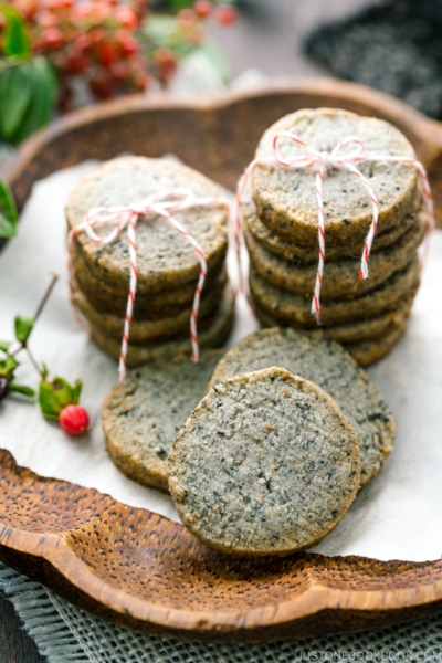 The wooden plate containing black sesame cookies.