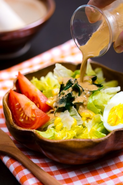 Japanese Sesame Dressing is poured over green salad.