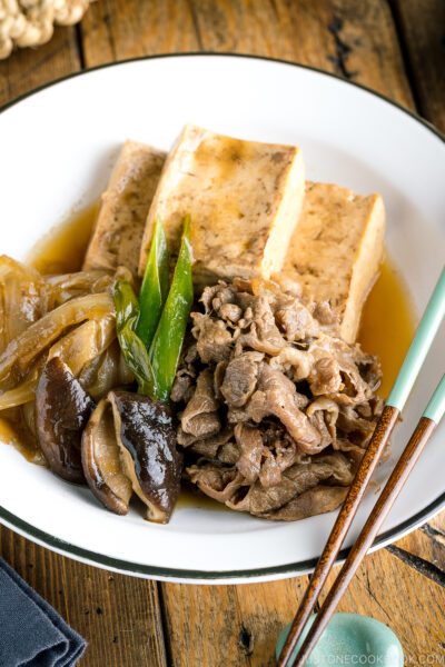 A white plate containing Japanese simmered beef and tofu (niku dofu).