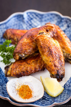 Japanese Salted Chicken Wings (Teba Shio) on the Japanese plate, along with a small plate of Shichimi Togarashi.