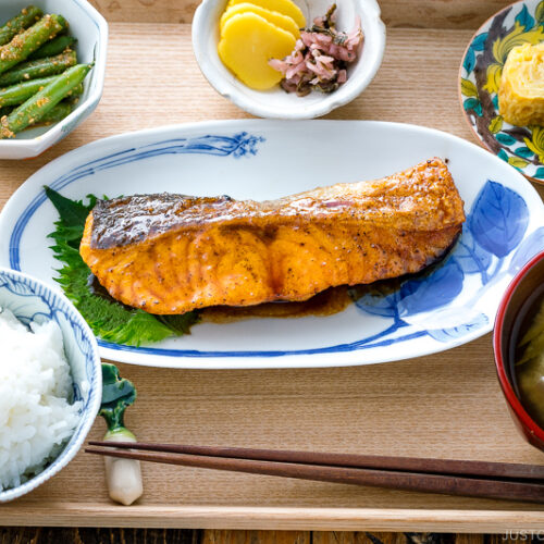 A plate containing Teriyaki Salmon served with steamed rice and miso soup.