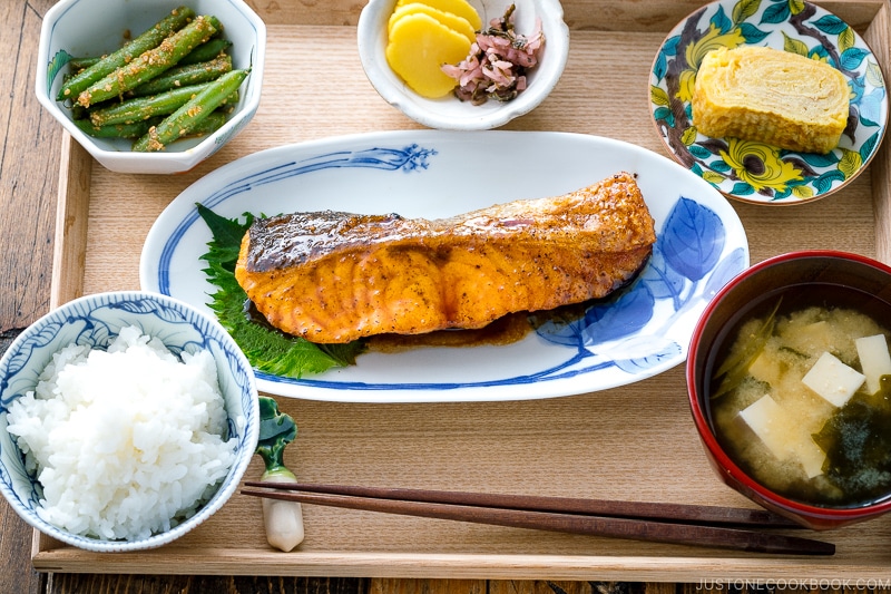 A plate containing Teriyaki Salmon served with steamed rice and miso soup.