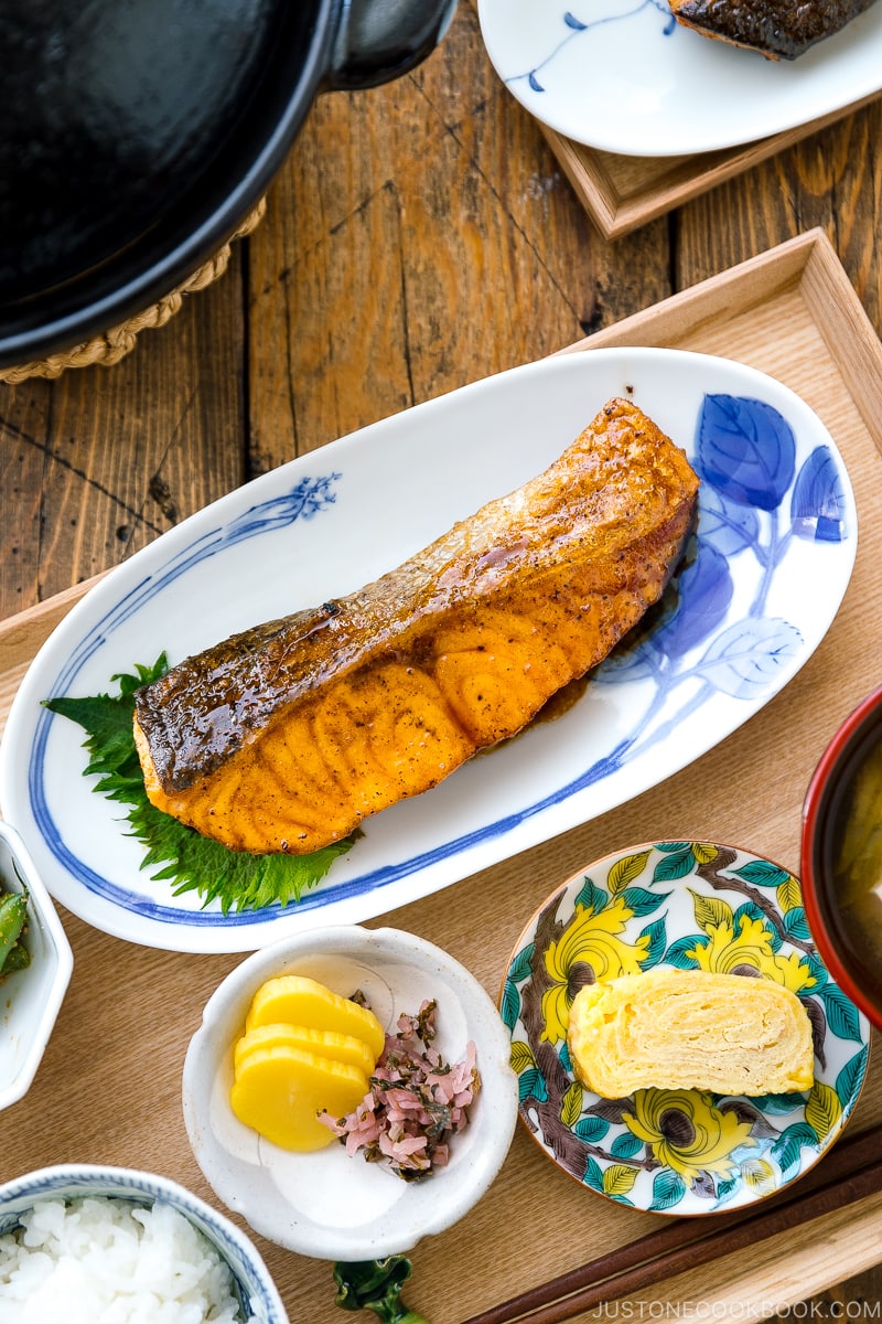 A plate containing Teriyaki Salmon served with steamed rice and miso soup.