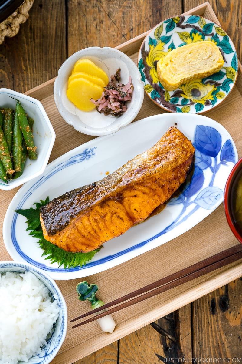 A plate containing Teriyaki Salmon served with steamed rice and miso soup.