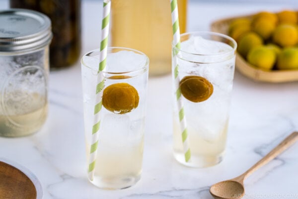 Tall glasses containing ume syrup cider and ume compote.