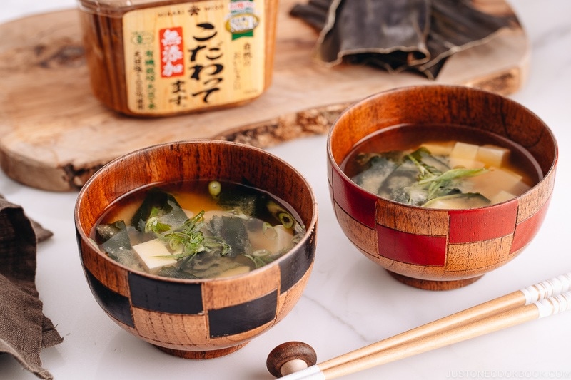 Japanese wooden bowls containing vegan miso soup with tofu and seaweed.