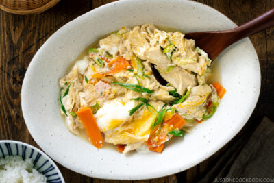 A white ceramic bowl contaiing Yuba Tamagotoji (Simmered Tofu Skin with Soft Scrambled Eggs).